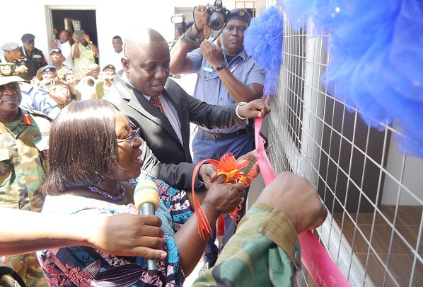 Mrs Akosua Frema Osei Opare (left) being assisted by Mr Dominic Nitiwul (Right), the Minister of Defence, to cut the tape to inaugrate the newly installed oxygen plant at the 37 Military Hospital in Accra