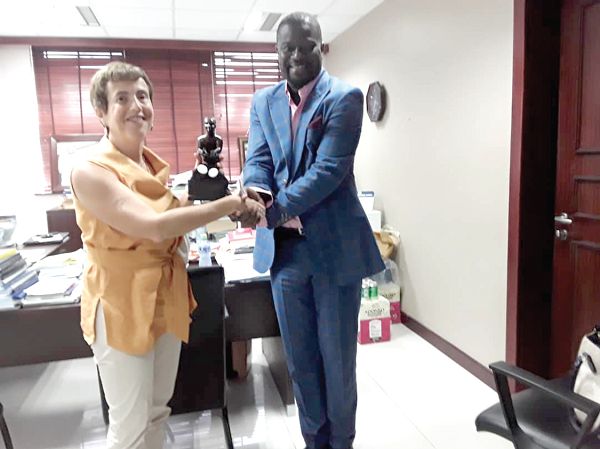 Mr Frank Annor-Dompreh presenting an artefact to Ms Diana Acconcia