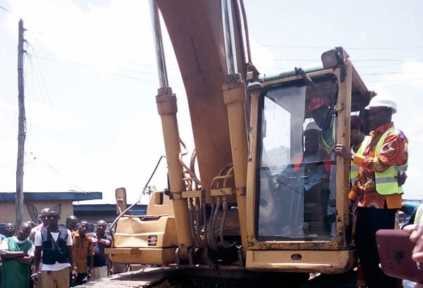 Mr Ishmael Ashitey takes over the controls of an excavator to cut the sod for commencement of work
