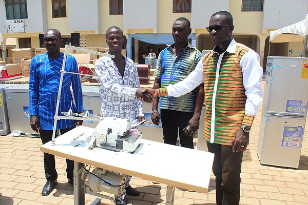  Mr Offinam Takyi (right) presenting a knitting machine to one of the beneficiaries