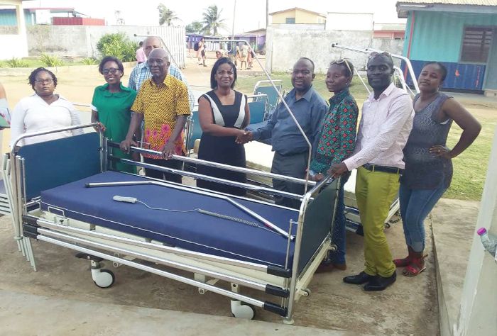  Mr Adu-Amankwah (4th right), leader of the delegation, handing over some medical equipment to Mrs Nana Konadu Darko, the Medical Officer in-charge, Manhean Polyclinic, Tema. Those with them include some health officers and the delegation from Belgium