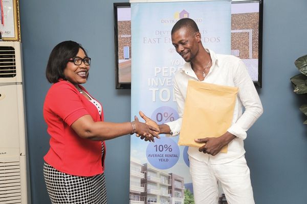 Mr Fatau Alhassan in a handshake with Mrs Joannita Yorke, after receiving the lease documents covering his house