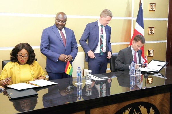 Ms Shirley Ayorkor Botchway and  Mr Jeremy Hunt signing the agreement. Behind them are  Dr Mahamudu Bawumia, the Vice-President and Mr Iain   Walker,  the British High Commissioner. 