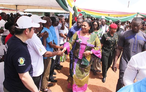 Mrs Rebecca Akufo-Addo (right), the First Lady, exchanging pleasantries with some officials at the event. INSET: Some residents going through medical screening. Picture: EDNA ADU-SERWAA