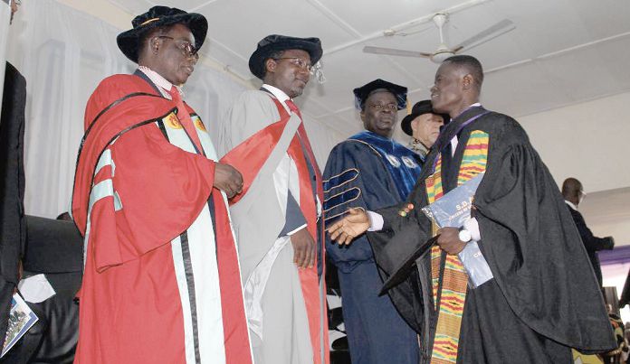 Mr Benjamin Apraku Mensah (right), who had first class, being congratulated by Pastor Dr Thomas Ocran (2nd left), President, Southern Ghana Union of the SDA Church, Prof. Fred Ocansey (left), Member of the Academic Board of the University of Cape Coast, and Prof. William Koomson (3rd left)