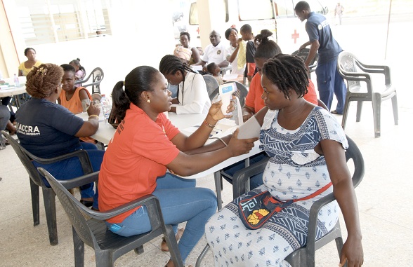 Miss Emmanuella Adu (left), a nurse at the University of Ghana Hospital, Legon, examining Ms Mary Akotua (left), a resident of Menpeasem during the health screening exercise organised by the Accra Technical University on the university’s new campus. Picture: ESTHER ADJEI