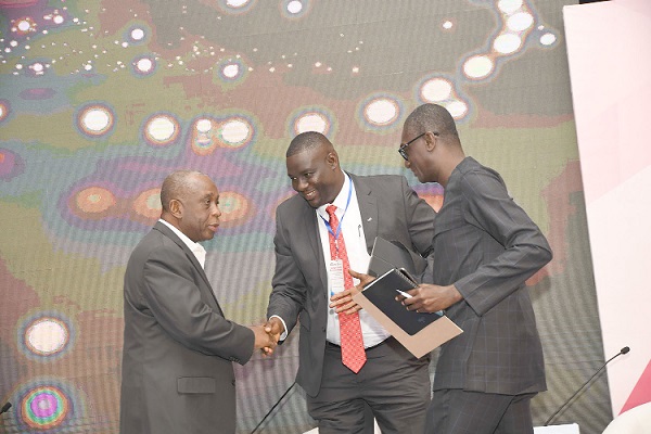 Mr Edward Gomado (middle) in a hand shake with Mr Neustadt Amarteifio (left) and Mr Nuamah Eshun-Famiyeh both speakers at the breakfast meeting