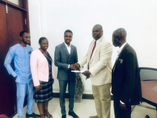 Prof Owusu-Agyei (2nd right) presenting documents to Mr Ampofo-Domfeh, while Mr Joseph Acheampong, Director of Projects of the company (right) looks on