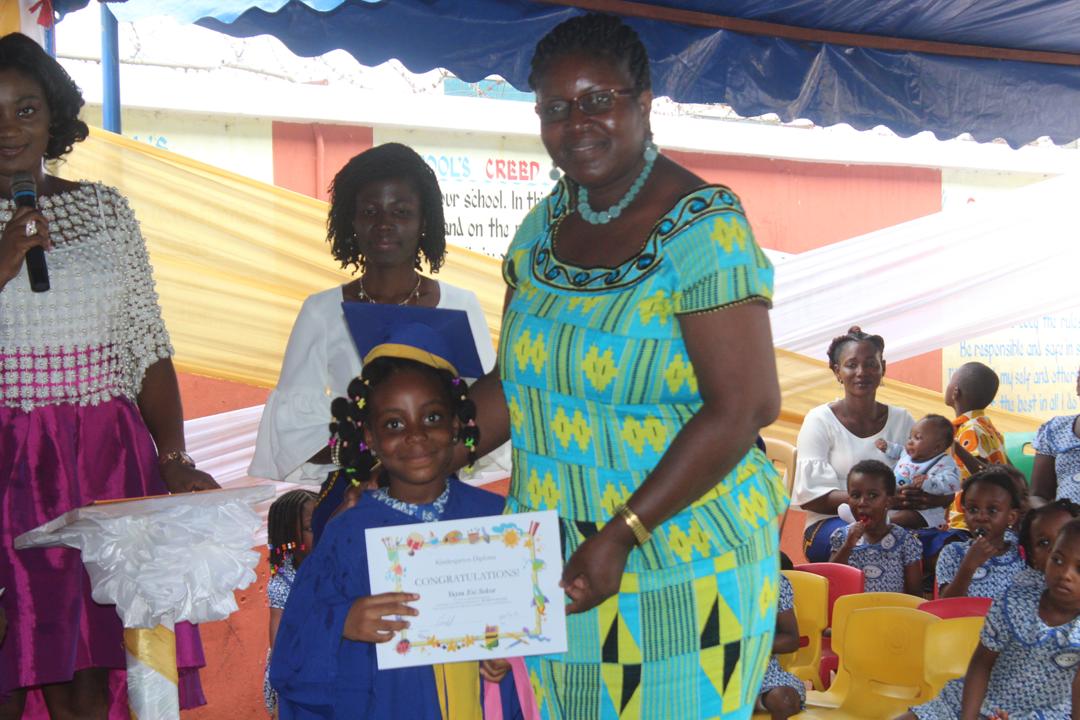 Mrs Gifty M. Azeko, Guidance and Counselling Coordinator, Tema Metro Office of the Ghana Education Service (R), presenting a certificate to one of the graduands.