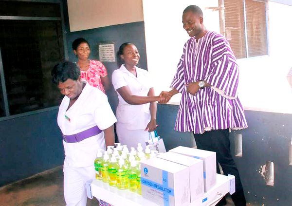 Mr Nashiru Iddrisu (right) presenting the items to a nurse of the hospital