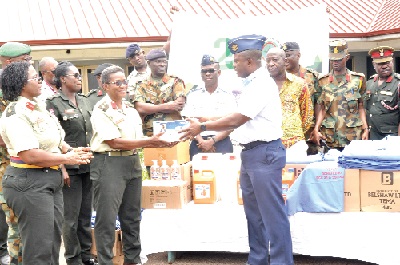 Group Captain Thomas Okai (right) handing over some items to Col. Josephine Vowotor (3rd left), Chief Nursing Officer, 37 Military Hospital. Picture: NII MARTEY M. BOTCHWAY