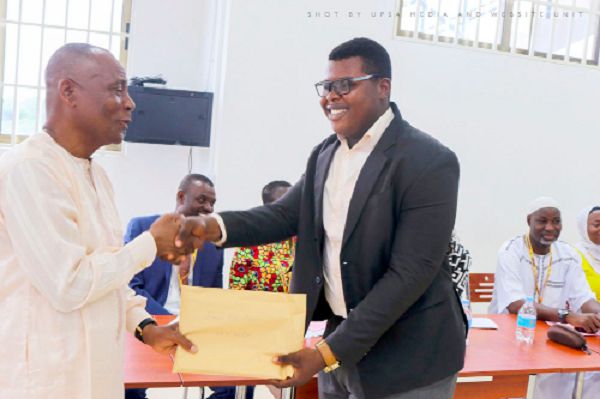 Mr Abubakar Boniface Saddique presenting an excellence and discipline award to one of the beneficiaries