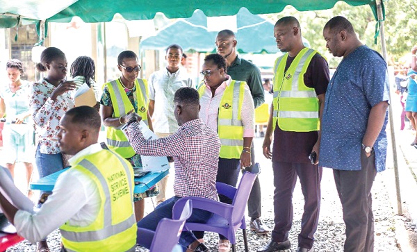  Mr Mustapha Ussif (second right), the Executive Director of the National Service Scheme, and his deputies interacting with some officers at the registration centre