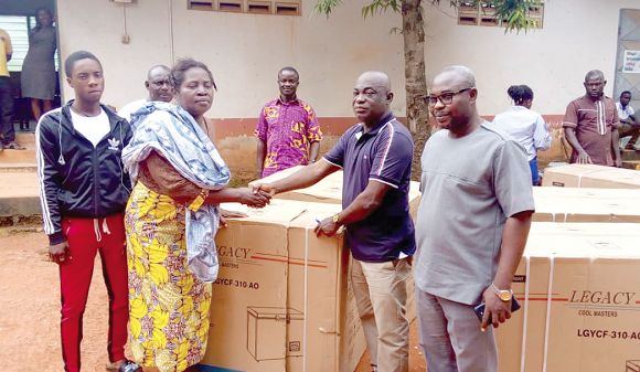 Mr Dennis Armah-Frimpong (2nd right), DCE for Agona East, presenting a deep freezer to one of the beneficiaries
