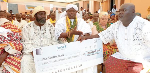The Assistant Secretary of the Naa Densua Family, Mr Stanley Nii Aryee Hammond (right), displaying the cheque for GH₵20,000 after it was presented to him by Papa Nii Masope-Crabbe (middle). Looking on is Nii Gbelenfo (left), the spiritual head of the Densua Family,