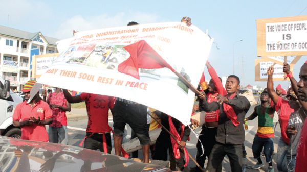 Some of the demonstrators holding aloft a banner against rampant road accidents at Ayigbe Town junction off Kasoa highway. Picture: Patrick Dickson 