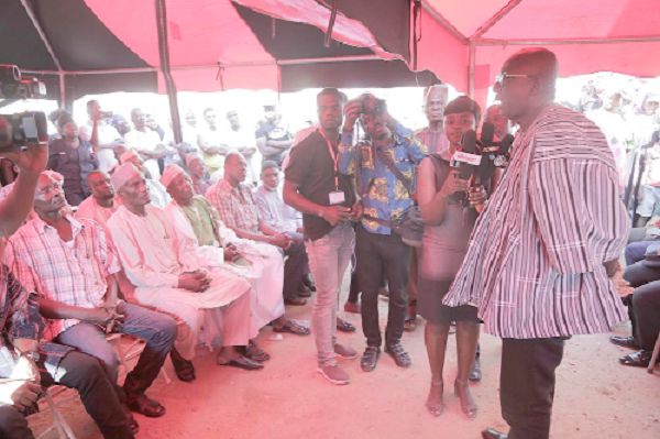 Mr Ambrose Dery (right)  addressing the family members of the late Mohammed Awal when he and the police delegation visited them