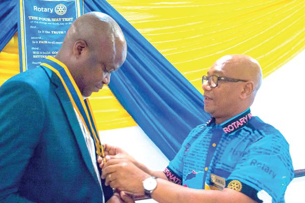 Mr Tettey-Ahwah (left) being decorated by Rotarian Alhaji Baba  Awal, past Assistant Governor during the swearing in ceremony in Kumasi