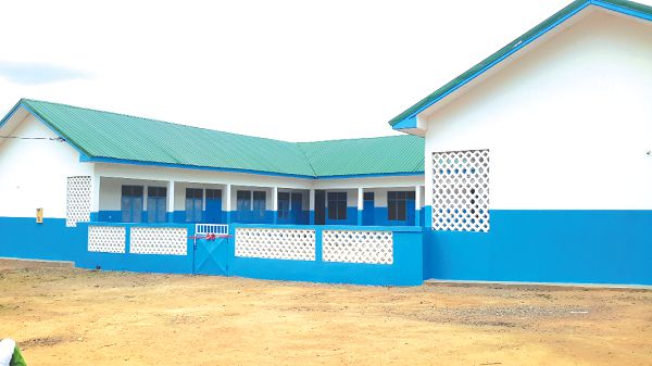 • The new classroom block. INSET: Alhaji Issahaku Moomin (2nd left) cutting the tape to inaugurate the school block 
