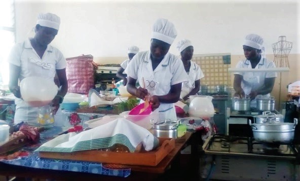 Some students of the Christian Methodist Senior High School doing their Home Economics practical examination under supervision   