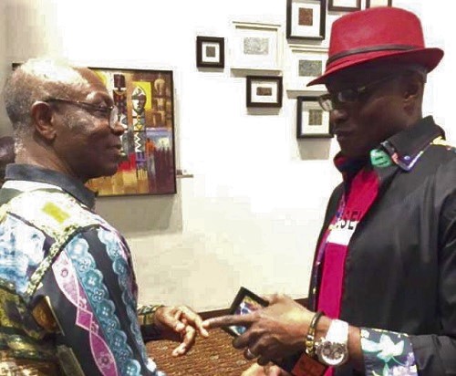 Mr Eddie Annan (left) interacting with an Art_233 member, Yaw Safori, at the opening of the exhibition