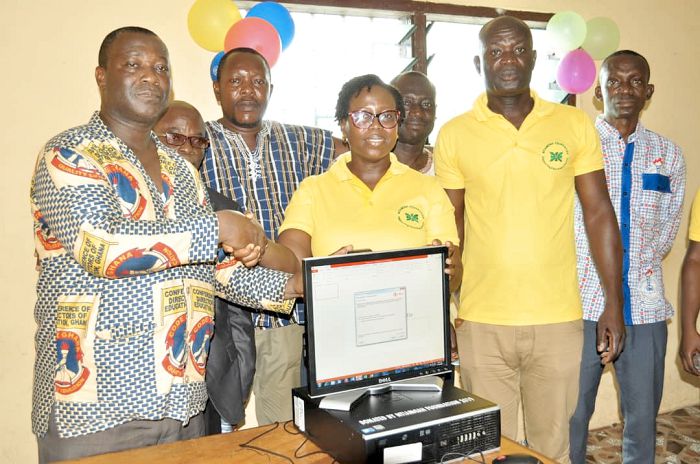Mr Isaac Okyere (left) receiving one of the computers from Ms Mercy Quansah Ansah