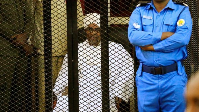 Omar al-Bashir sat in a cage as he was sentenced for corruption