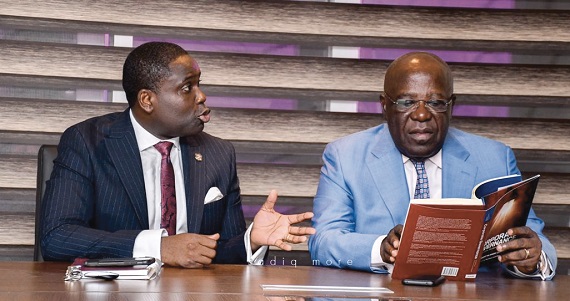 Nii Arday Clegg (left), the author explaining aspects of the book to Mr Sam Jonah