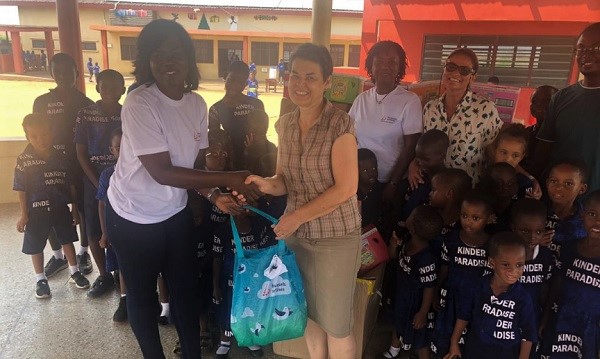 Maame Asantewaa Okyere, Sales and Account Manager of Brussels Airlines (left) presenting the clothes to the Project Leader Assistant of Kinder Paradise, Heike Drechsel-Atta