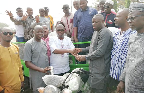 Dr Ibrahim Mohammed Awal (3rd right) handing over the keys to one of the tricycles to Mr Sule Salifu  