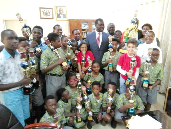  Dr Yaw Osei Adutwum (arrowed), with the awardees with their trophies and some staff of UCMAS as well as coaches from beneficiary school