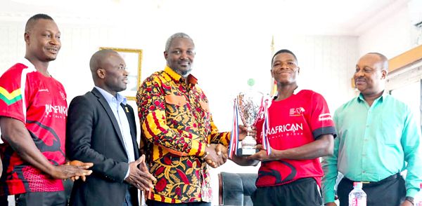 A member of the rugby team presenting the trophy to the Deputy minister of Youth and Sports, Mr Perry Okudzeto, as Prof. Peter Twumasi (2nd left), NSA director General, looks on