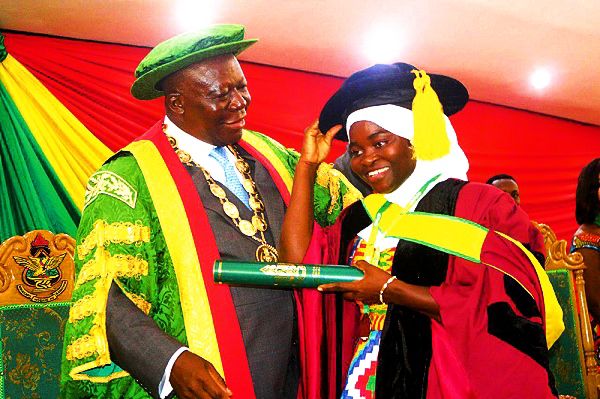 The Asantehene, Otumfuo Osei Tutu II,  embraces Mrs Nusrat Tsemah Afful, who obtained a Doctor of Philosophy honours in Plant Breeding, during a special convocation at the Great Hall of the Kwame Nkrumah University of Science and Technology (KNUST). Picture: EMMANUEL BAAH