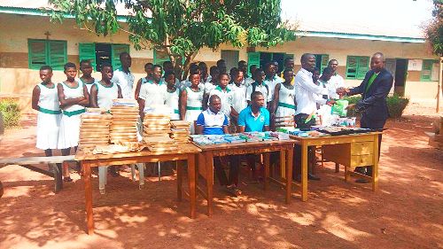 Mr Ignatius Kansanga (right) presenting the items to Mr Benjamin Dery, while some of the students and teachers look on