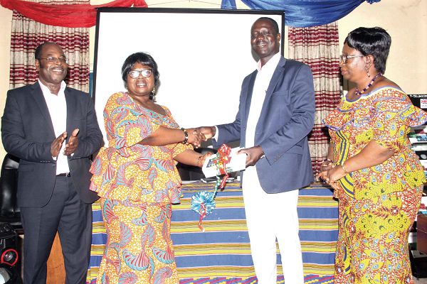 Dr Evelyn Owusu Oduro handing over copies of the guide books to Dr Samuel Atintono, Principal, Accra College of Education (ACE). Those with them are Prof. Jonathan Fletcher (left) and Ms Frances Williams. Picture: Maxwell OCLOO