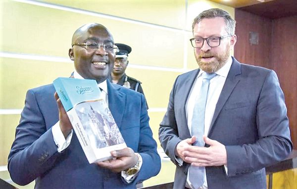 Vice-President Dr Mahamudu Bawumia displaying a book presented to him by Mr Christian Kattner, General Secretary, IDU at the Jubilee House in Accra during the meeting