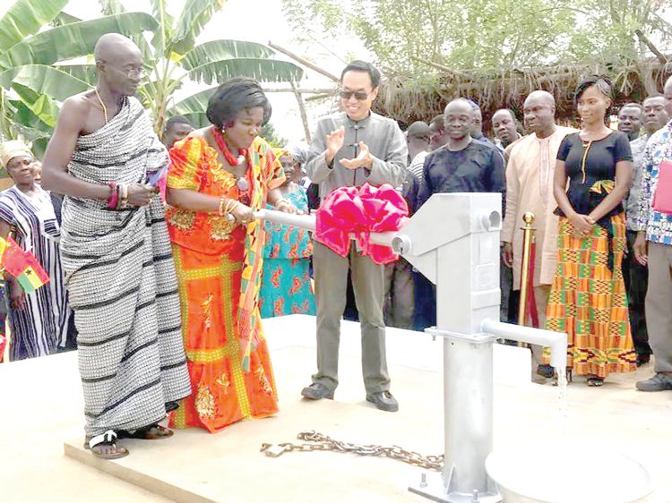 Ms Cecilia Dapaah (middle), taking delivery of the boreholes at the ceremony, while Mr Shi Ting Wang (right) the Chinese Ambassador applauds. With them is the Chief of Densuso, Nana Baffuor Adu Ameyaw II