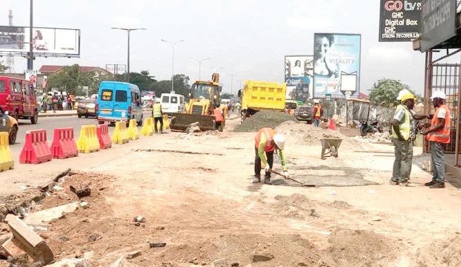 Construction workers busy at work at the intersection.