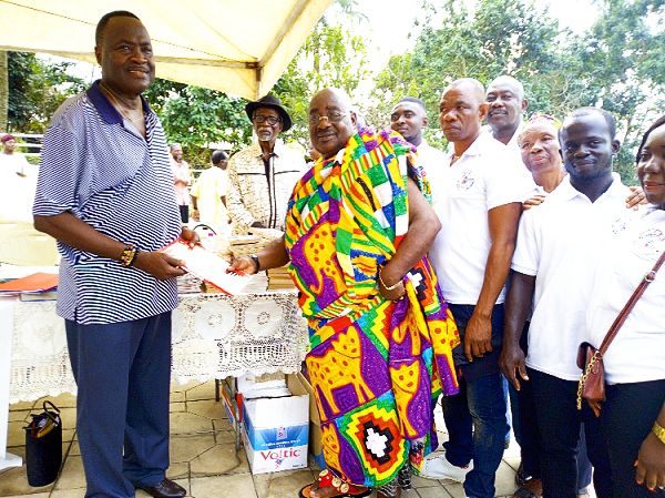 Mr Gadiel Ofori Annor (left), patron, OBS World Foundation, presenting a set of books to Nana Okofo Ayeh Bekoe I, Chief of Obosomase Akuapem