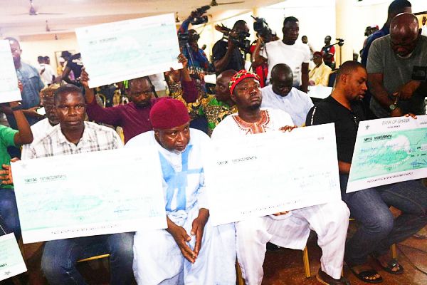  Relatives of the seven deaceased displaying their dummy cheques for GH¢250,000 each. Picture: EMMANUEL BAAH