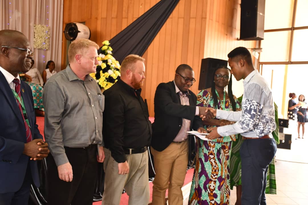 Mr Augustine Okyere of DRA Ghana (left) presenting an award to Amoako-Atta Hussein, one of the beneficiary students. On his immediate right are Willem Postma and Neale Goddard all of DRA