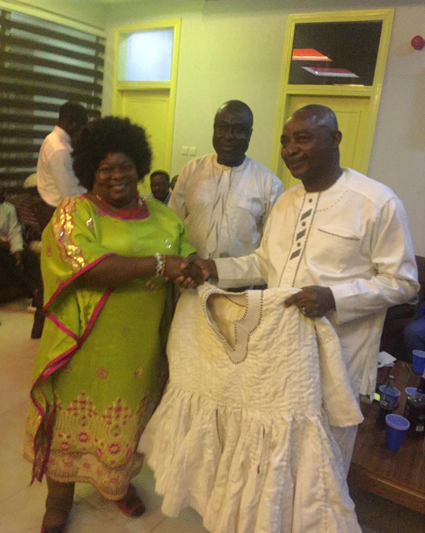 Mrs. Paulina Jimah a.k.a. Mama Gee, a member of the Tennis Club (left) on behalf of the Club is seeing presenting the Smock to Brigadier General Alhassan ( right). Standing in the middle is Mr. Salifu Seidu Abebe.