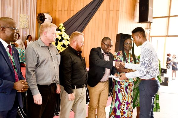 Mr Augustine Okyere of DRA Ghana presenting an award to Hussein Amoako-Atta, one of the beneficiary students. On his immediate right are Willem Postma and Neale Goddard all of DRA