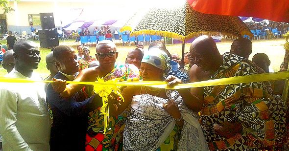Nana Adomfe Agyei (right) assisting Nana Afia Serwaa to cut the tape to inaugurate the project while Dr Dapaah-Siakwan and other dignitaries look on. INSET: Front view of the new school block at Adomfe after its inuaguration