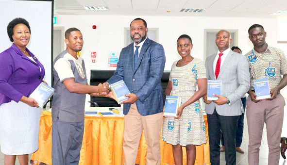 Dr Mathew Opoku-Prempeh (middle) presenting samples of the book to the Headmaster of Keta Business College Mr Etse Seake-Kwawu. With him are Mr Michael Luguje (2nd right), Esther Gyebi-Donkor (left) General Manager in charge of Corporate Affairs and Marketing. PICTURE: DELLA RUSSEL
