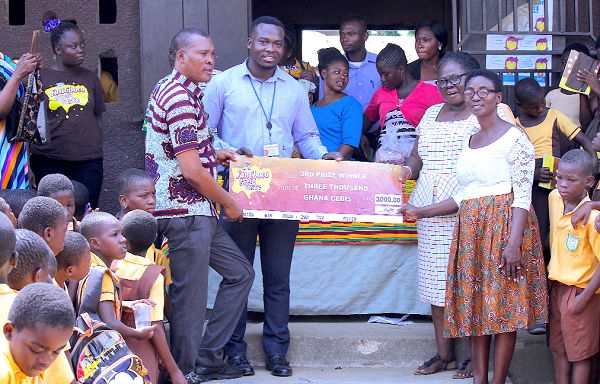  The Brand Manager of FanMilk Ghana Limited, Mr Abdul Razak Suleman  (2nd left), being assisted by the Ashaiman Municipal Sport’s Director, Mr Edem Dela (left), presenting a dummy cheque for GH¢3,000 to the Headmistress of the school, Miss Comfort Oduro Kwarteng and  her assistant, Mrs Christine Akley.