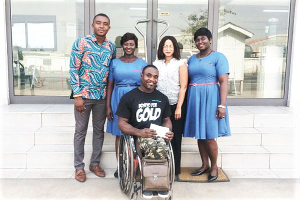 Botsyo Nkegbe with some staff of Wire Weaving displaying the cheque