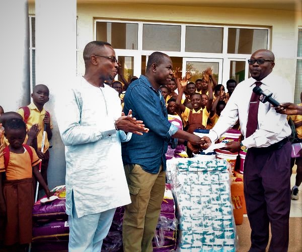 Mr Bekoe (left) presenting the cash to Mr Ametewee(in tie). With them is Mr Kwamena Duncan, the Central Regional Minister (extreme left) and some of the students