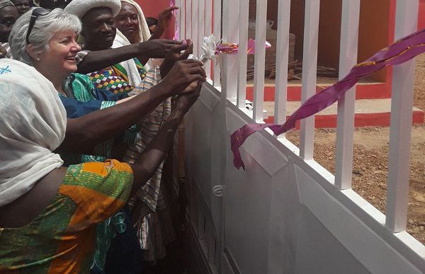 Madam Sullivan (middle), the US Ambassador to Ghana, being assisted by the Chief of Gizaa Gundaa to cut the tape to inaugurate a warehouse and a shea processing centre for the Yu rilim Women’s Shea Cooperative in the community.