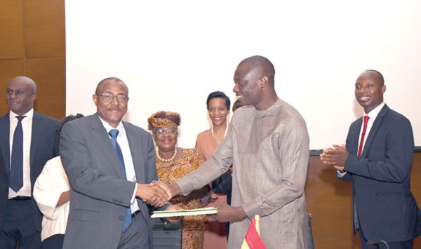 Mr Kwaku Agyemang Kwarteng (right), a Deputy Minister of Finance, exchanging the signed document with Mr Mohamed Beavogui, Director General of Africa Risk Capacity, after the signing ceremony. With them are some board members of the ARC. Picture: EBOW HANSON